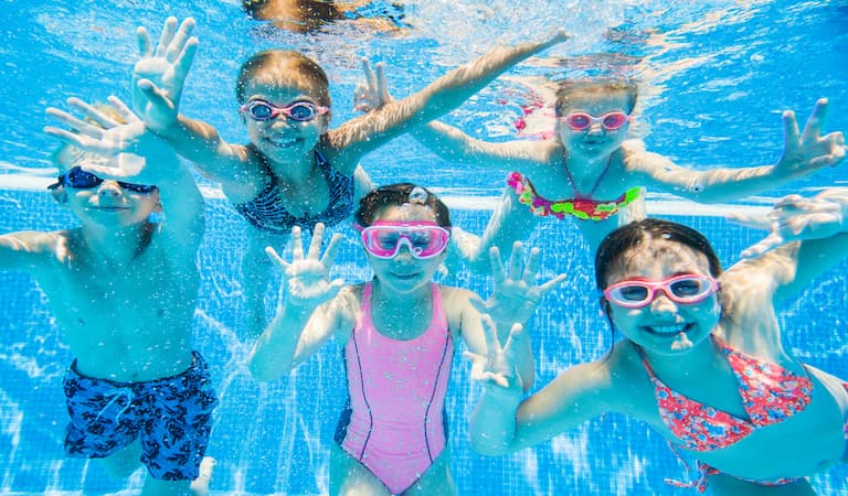 Group of children underwater in a swimming pool.