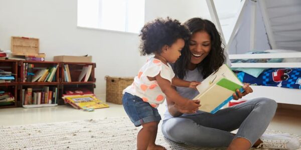 Mother and young daughter reading books at home.