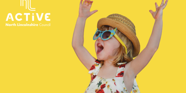 picture of a young girl in sunglasses with her arms up in the air having fun