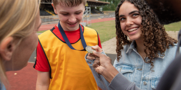 Tom foster child with fostering family after winning his running race
