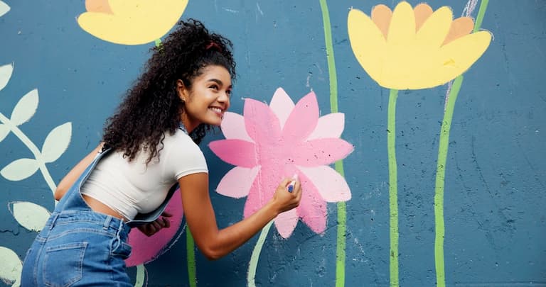 A young woman creating a wall mural