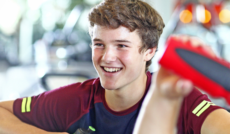A boy smiling in a gym
