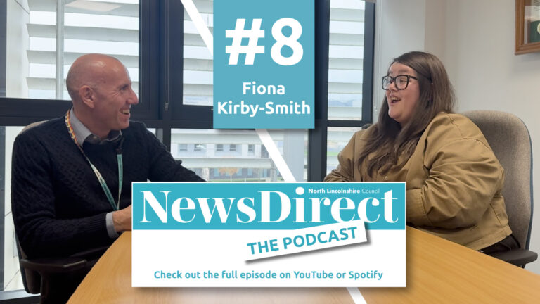 Two people talking across a desk for the eight episode of the News Direct podcast
