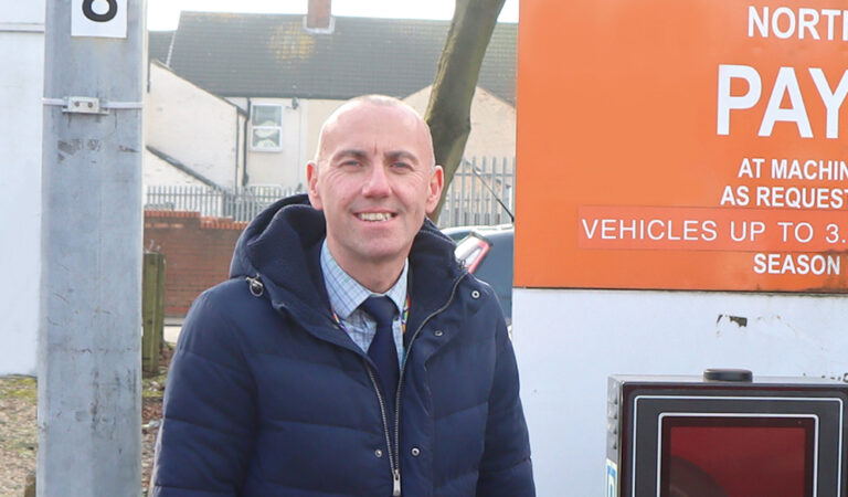 Cllr Rob Waltham in West St car park next to a ticket meter.