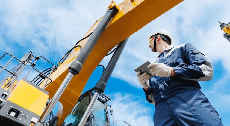 Male engineer using a tablet to check construction equipment for AI story