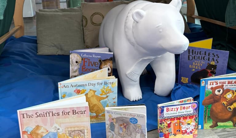 A white model of a bear cub surrounded by children's books about bears